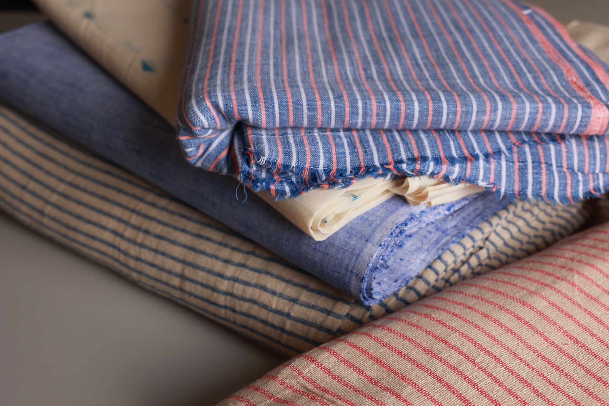 Stack of striped fabric swatches in various colors, handwoven, handloom from India 