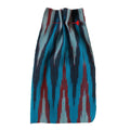 Textile with blue, red, and black pattern on a beige background. Ikat collection ATELIER A.PUUR.A 