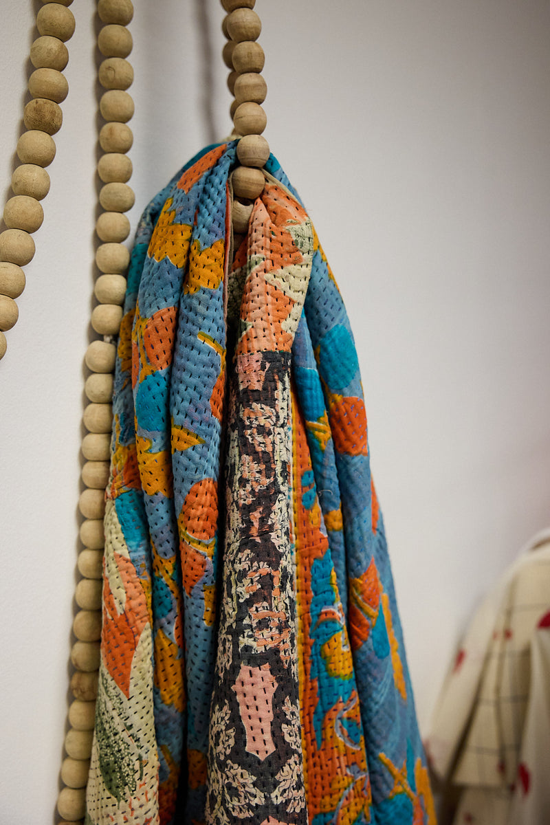 A colorful kantha plaid hanging on a beaded cord in ATELIER A.PUUR.A shop 