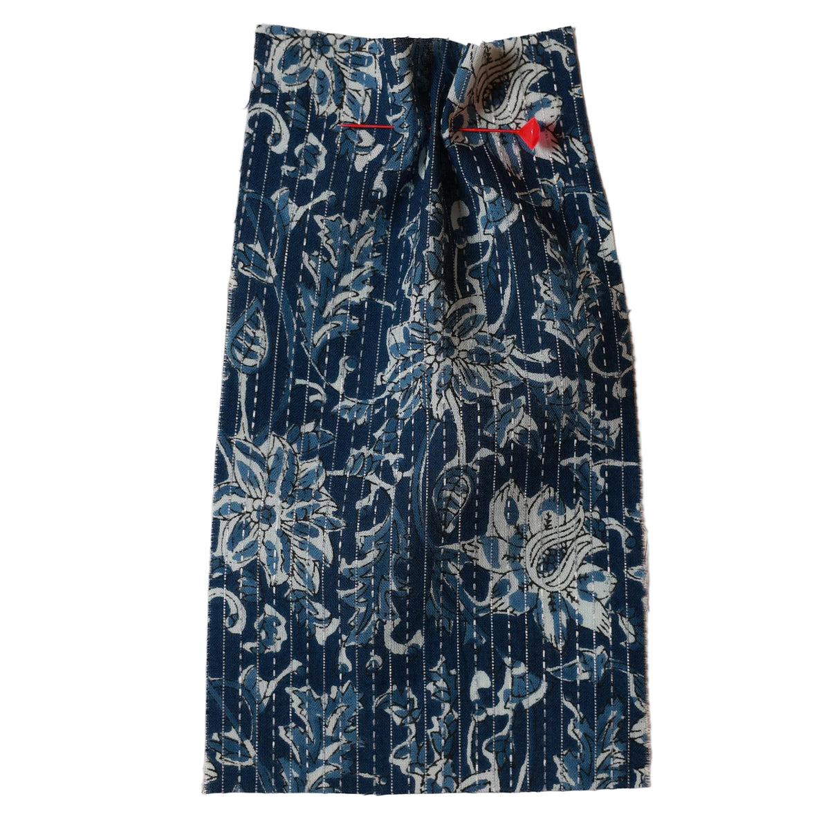 Printed Blue floral patterned fabric with a red needle on a beige background